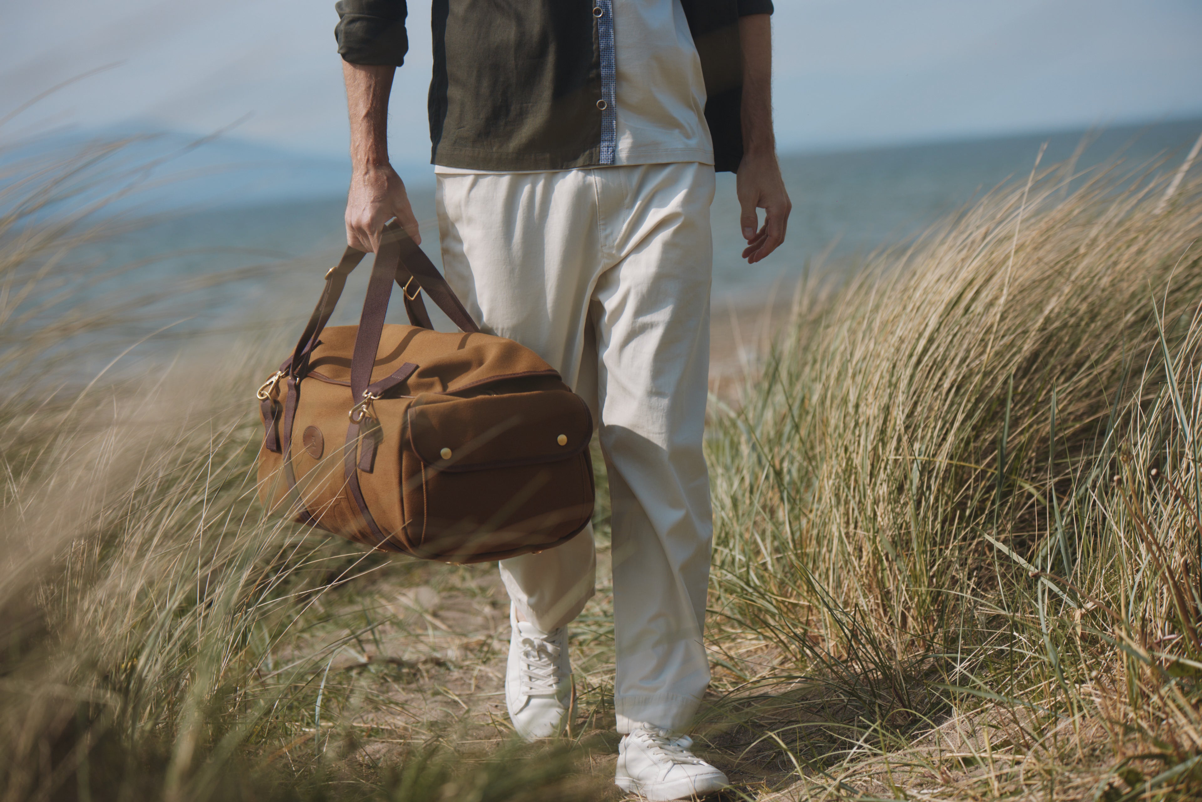 Man walking with Chapman bag through sand dunes